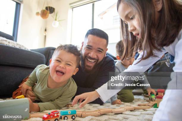 father and children play with wooden train set - one clild has down syndrome - auckland train bildbanksfoton och bilder