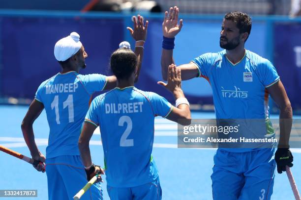 Rupinder Pal Singh of Team India celebrates scoring a penalty shot with Mandeep Singh and Dilpreet Singh during the Men's Bronze medal match between...