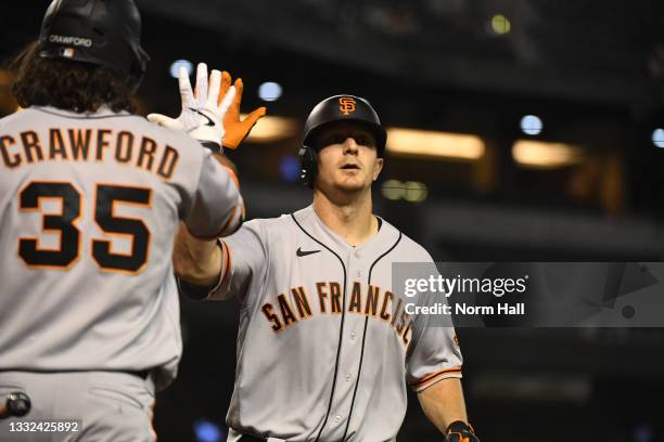 Alex Dickerson of the San Francisco Giants celebrates his three-run home run with Brandon Crawford off of Jake Faria of the Arizona Diamondbacks in...