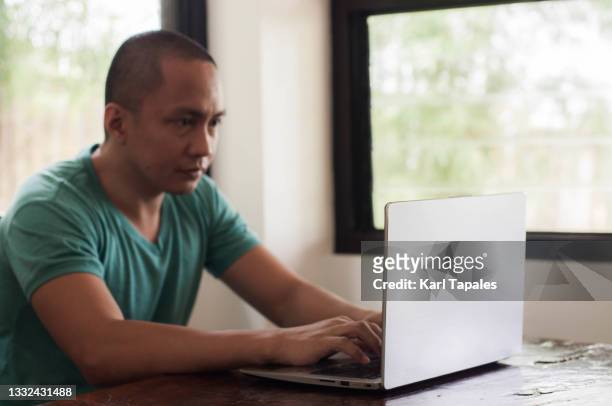 a young southeast asian male entrepreneur is working remotely - daily life in philippines stock-fotos und bilder