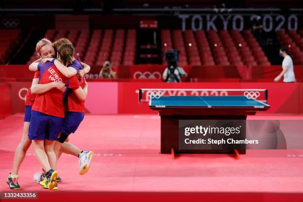 Minnie Soo of Team Hong Kong is hugged by her teammates Doo Hoi Kem and Lee Ho Ching after winning their Women's Team Bronze Medal table tennis match...