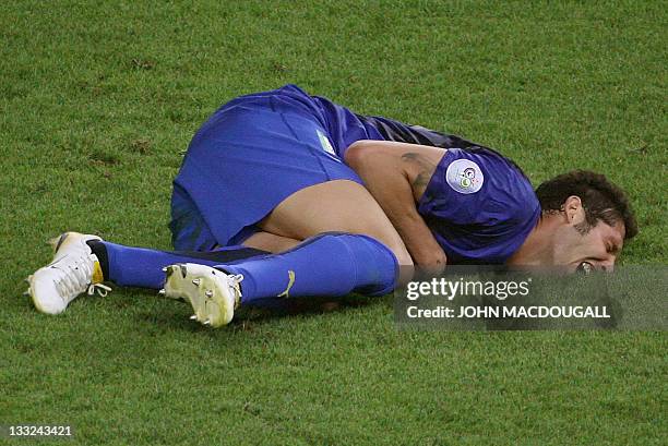 Italian defender Marco Materazzi lies on the pitch after receiving a head butt by French midfielder Zinedine Zidane during the World Cup 2006 final...