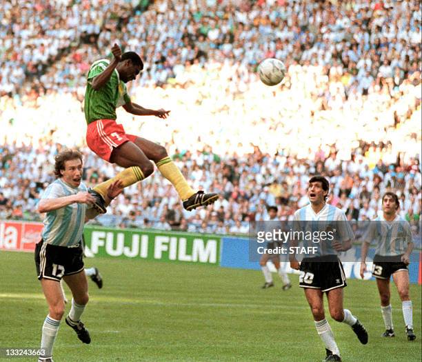 Forward Francois Omam-Biyick from Cameroon scores on a header as Argentinian defenders Nestor Lorenzo and Juan Simon look on 08 June 1990 in Milan...