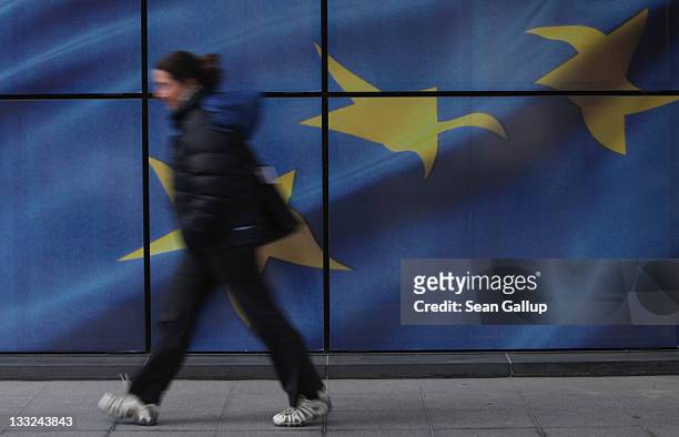Young woman walks past a wall decorated with the flag of the European Union outside one of the buildings of the European Commission on November 17,...