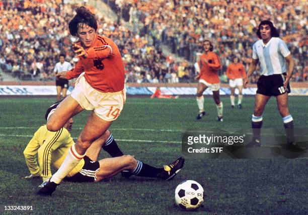 Dutch midfielder Johann Cruyff dribbles past Argentinian goalkeeper Daniel Carnevali on his way to scoring a goal during the World Cup quarterfinal...