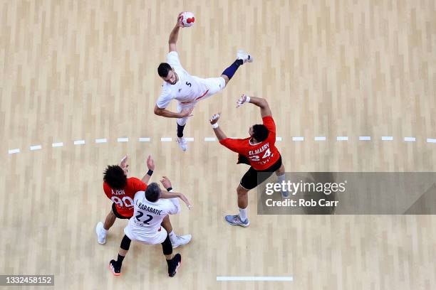 Nedim Remili of Team France shoots for goal over Ali Mohamed and Ibrahim Elmasry of Team Egypt as Luka Karabatic of Team France looks on during the...