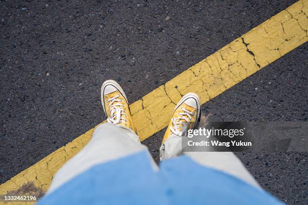 one foot on the yellow line of the road - yellow line stock pictures, royalty-free photos & images