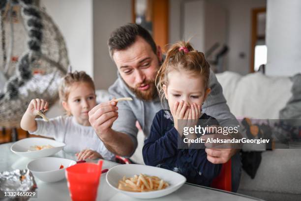 modern father worried about not being able to convince female children to eat french fries - family eating potato chips stock pictures, royalty-free photos & images