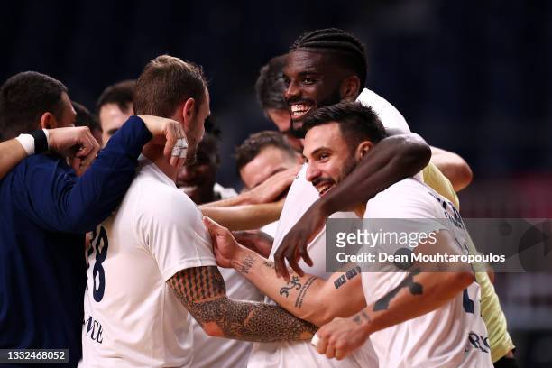 Hugo Descat and Dika Mem of Team France celebrate with teammates after winning the Men's Semifinal handball match between France and Egypt on day...
