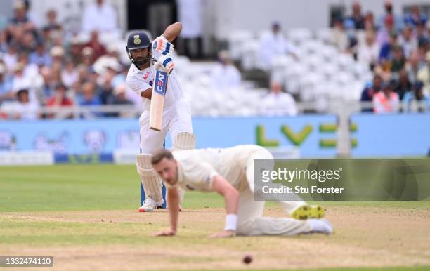 England bowler Ollie Robinson looks on as India batsman Rohit Sharma off drives past him for 4 runs during day two of the First Test Match between...