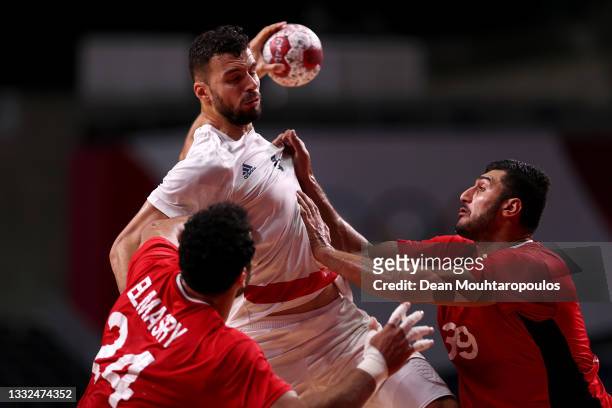 Nedim Remili of Team France is challenged by Ibrahim Elmasry and Yehia Elderaa of Team Egypt during the Men's Semifinal handball match between France...