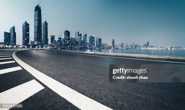 road by the sea in the city at night - empty road foto e immagini stock