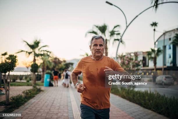 man jogging on the sidewalk - sweat stock pictures, royalty-free photos & images