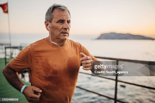 桟橋で一人でジョギングするシニア男性 - trying on ストックフォトと画像