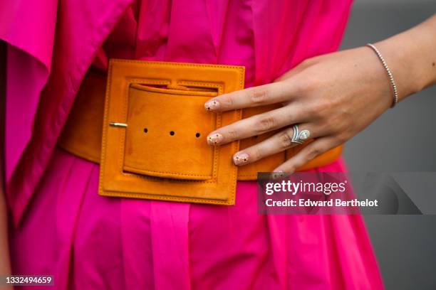 Gabriella Berdugo wears a Fuchsia neon pink nylon dress, an orange maxi belt from Natan, finger rings and jewelry, fantasy nail polish, on August 02,...