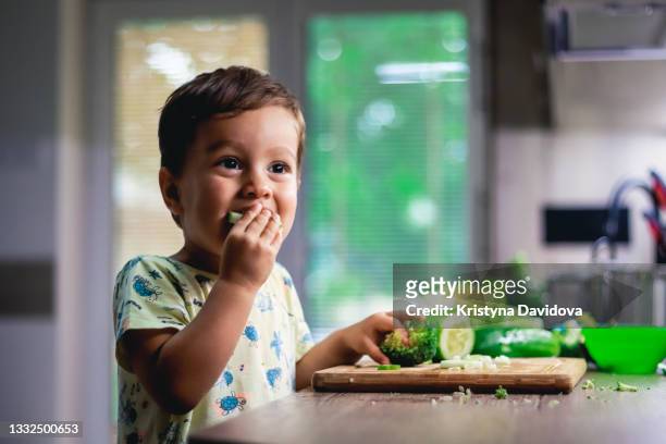 little boy eating vegetables - crudité foto e immagini stock