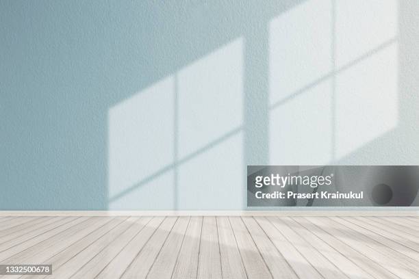 modern empty room with wooden floor and large blue concrete wall - woonruimte stockfoto's en -beelden