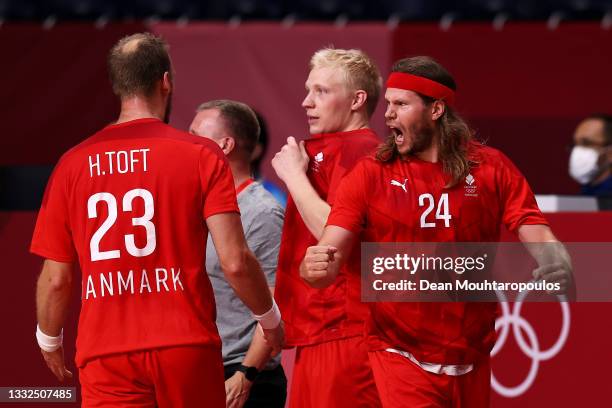 Henrik Toft Hansen, Magnus Saugstrup and Mikkel Hansen of Team Denmark celebrate winning after the final whistle of the Men's Semifinal handball...