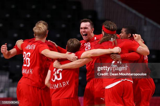 Lasse Andersson of Team Denmark celebrates with teammates after winning the Men's Semifinal handball match between Spain and Denmark on day thirteen...