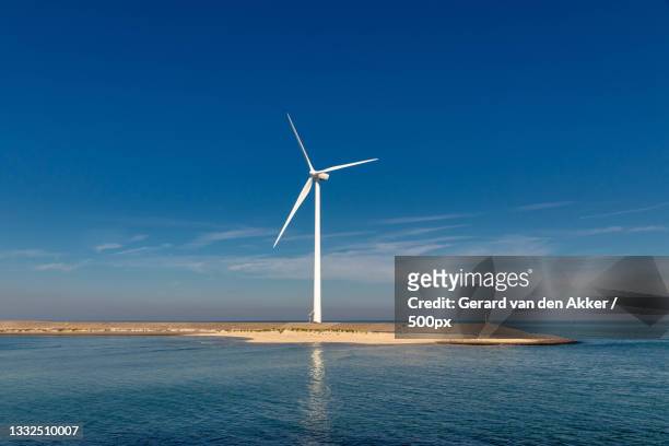 scenic view of wind turbines against blue sky - indagini di clima foto e immagini stock