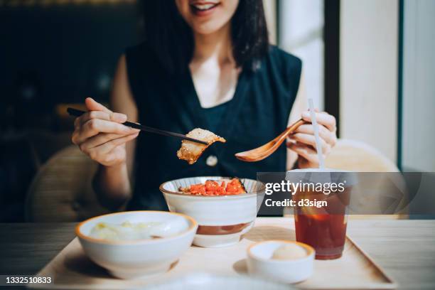 close up of smiling young asian woman enjoying freshly served traditional japanese yakiniku pork rice bowl with side dishes in restaurant. asian cuisine and food culture. eating out lifestyle - yakiniku - fotografias e filmes do acervo