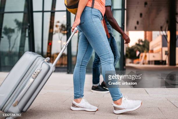 giovane donna che tira i bagagli all'aeroporto - man touching womans leg foto e immagini stock