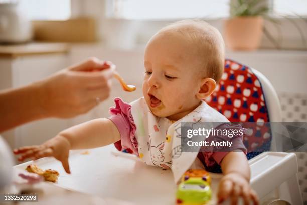 mother feeding baby in the kitchen - solid food stock pictures, royalty-free photos & images