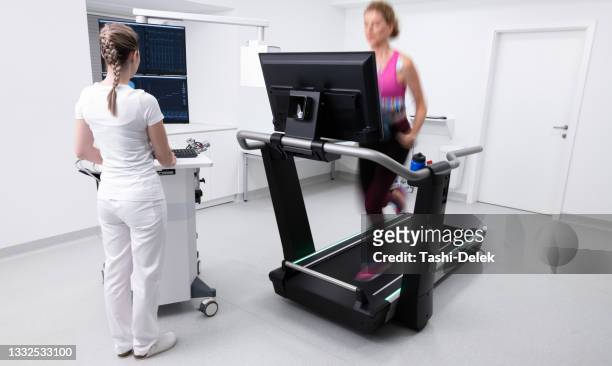 woman running on the treadmill ergometer during a cardiopulmonary stress test - stress test stock pictures, royalty-free photos & images