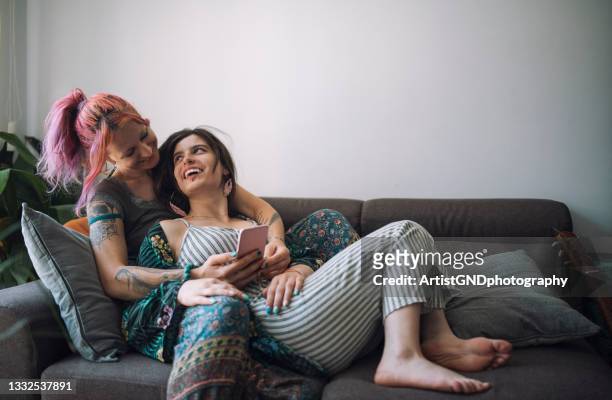 lesbian couple using phone at home - lesbian stock pictures, royalty-free photos & images