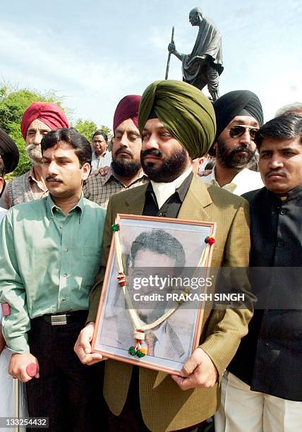 An activist of All India Anti-Terrorist Front hold a photograph of slain American journalist Daniel Pearl as they pay homage to him in New Delhi 24...