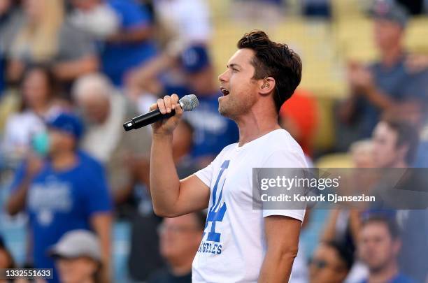 Drew Seeley, a Canadian-American actor, singer and dancer, sings the National anthem during the baseball game between the Los Angeles Dodgers and...