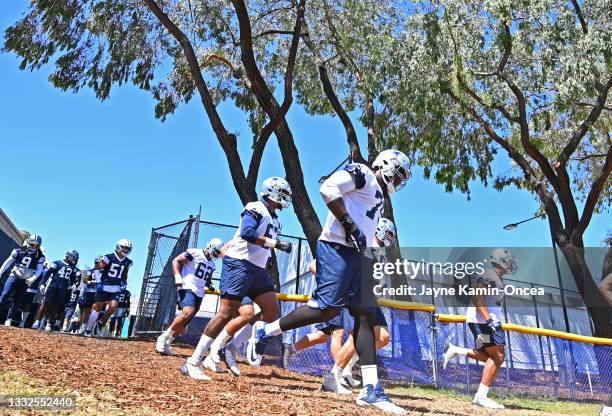 Dallas Cowboys run on to the field for training camp at River Ridge Complex on August 3, 2021 in Oxnard, California.