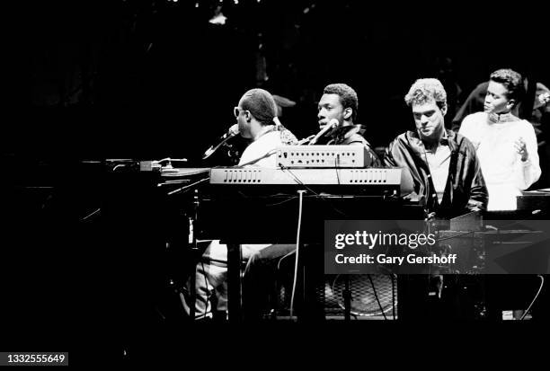 View of, from left, American R&B, Soul, Jazz, and Pop musician Stevie Wonder, on piano, as he performs onstage with guests, comedians Eddie Murphy...