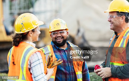Three multi-ethnic construction workers chatting Three multi-ethnic construction workers chatting