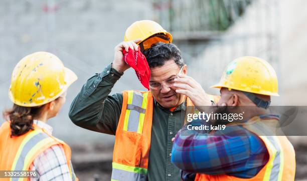 three multi-ethnic construction workers taking a break - mopping brow stock pictures, royalty-free photos & images