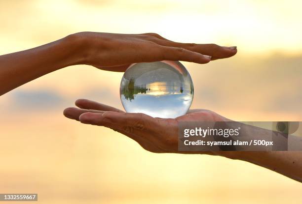 cropped hand holding crystal ball against sky during sunset,wara,sulawesi selatan,indonesia - new discovery stock pictures, royalty-free photos & images