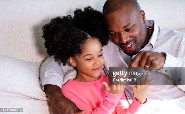 african-american father, girl on couch counting fingers - counting imagens e fotografias de stock