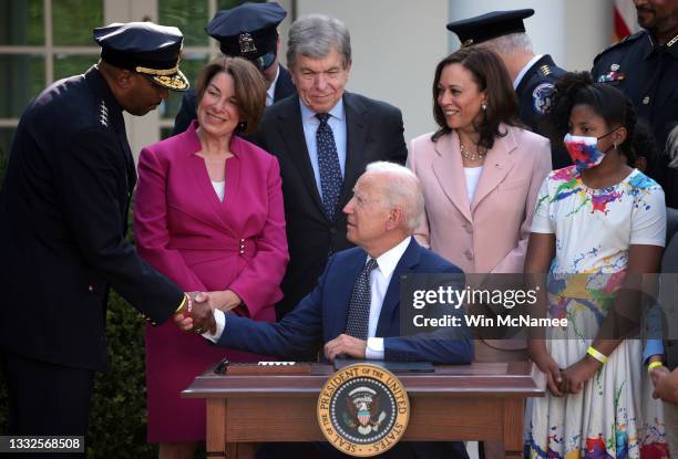 President Joe Biden shakes hands with Chief Robert Contee III, of the DC Metropolitan Police Department, after signing legislation to award...