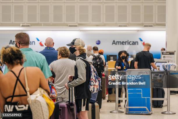 People wait in line at an American Airlines counter at the George Bush Intercontinental Airport, on August 05, 2021 in Houston, Texas. American and...