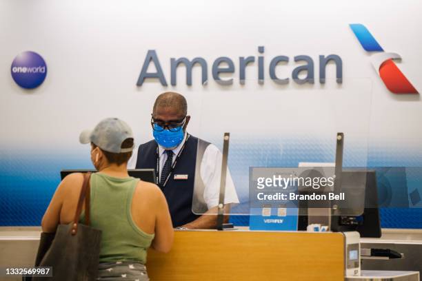 Customer is helped at an American Airlines check-in counter at the George Bush Intercontinental Airport on August 05, 2021 in Houston, Texas....
