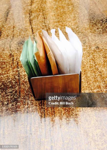 sugar substitutes in a metal container on a shinny granite table with light reflections - part of a series - artificial sweetener imagens e fotografias de stock