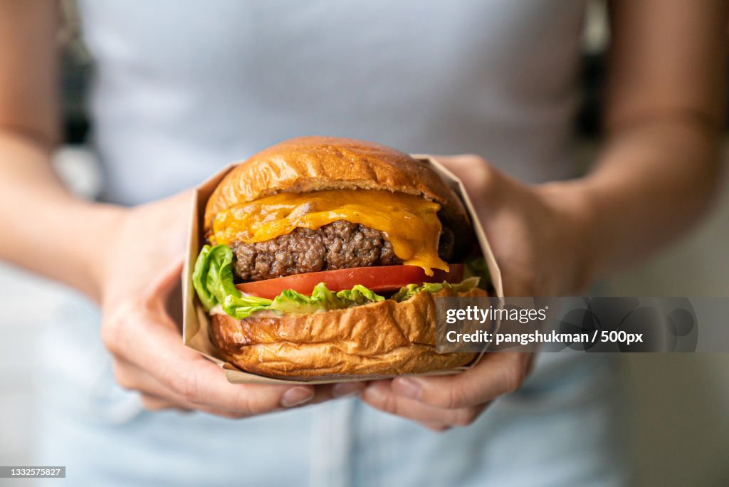 Midsection of woman holding burger