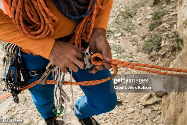 detail photo of climber threading belay device - rápel fotografías e imágenes de stock