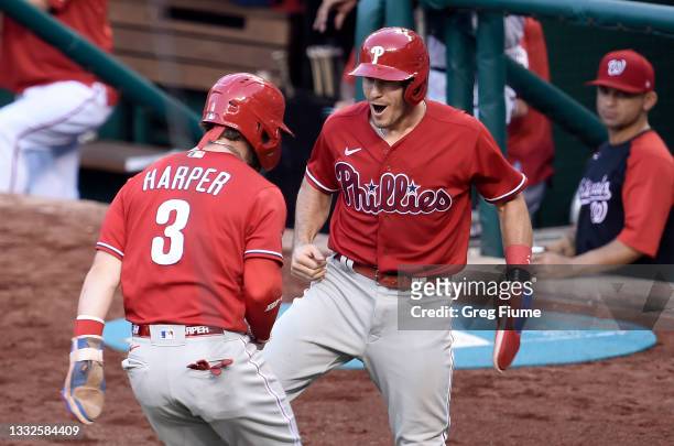 Realmuto of the Philadelphia Phillies celebrates with Bryce Harper after scoring in the ninth inning against the Washington Nationals at Nationals...