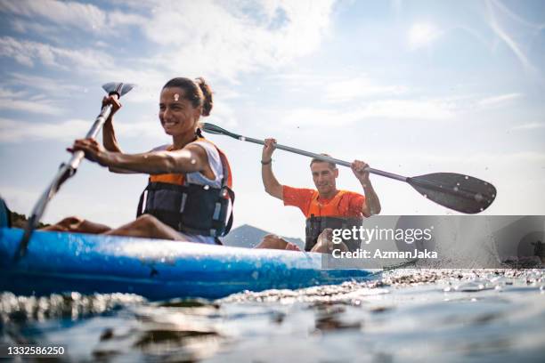 action-porträt von spanischen kajakfahrern, die das morgendliche training genießen - active couple stock-fotos und bilder