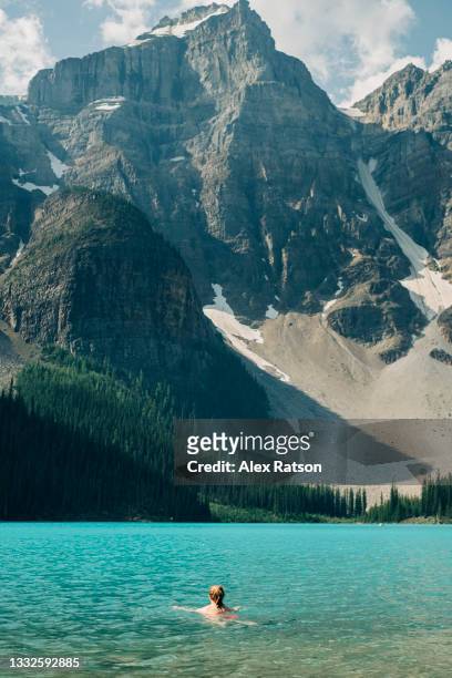 female swims in the cold water of moraine lake - canada landscape room for type stock-fotos und bilder