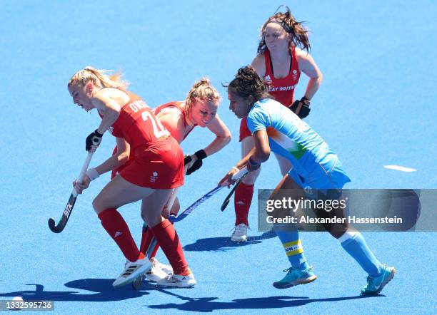 Hollie Pearne-Webb and Lily Owsley of Team Great Britain move the ball past Rani of Team India during the Women's Bronze medal match between Great...