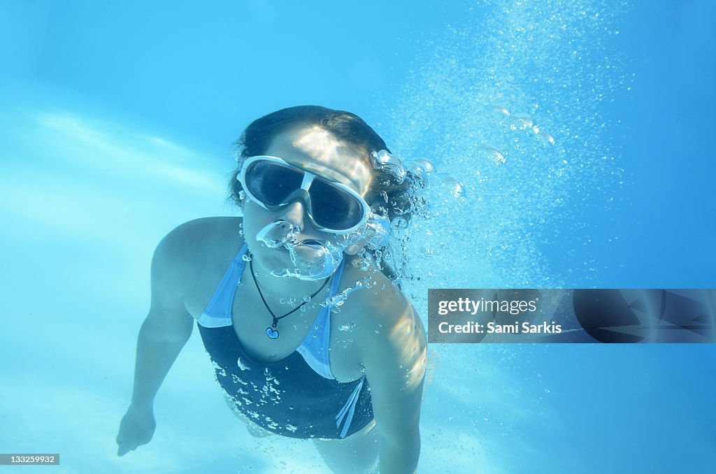 Girl swimming underwater in pool