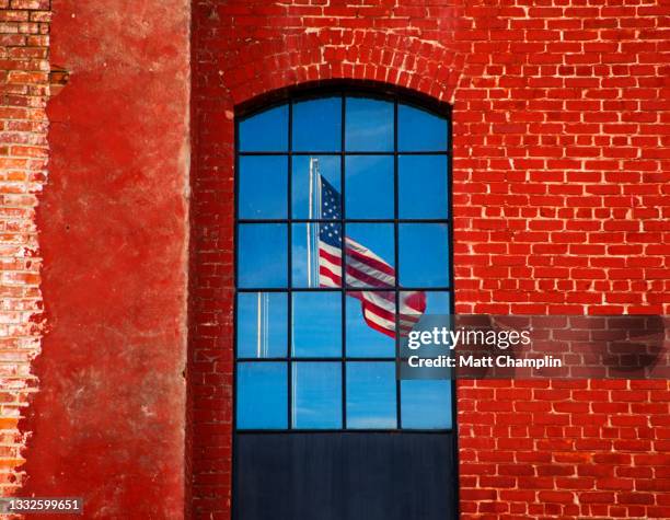 divided american flag in window - two paths: america divided or united stockfoto's en -beelden