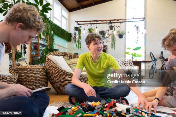 a boy with neurodiversity plays with his siblings - autism adult stock pictures, royalty-free photos & images